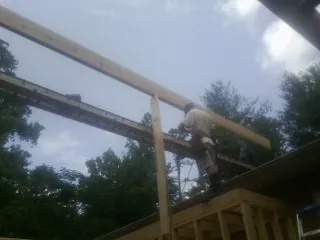 Carpenter setting a ridge beam over a new addition frame — Ice Dam Removal by Roofing Brothers in Ryde